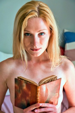Gorgeous blonde Gerda Rubia is sprawled on her bed in a loose white shirt that leaves her long slender legs bare